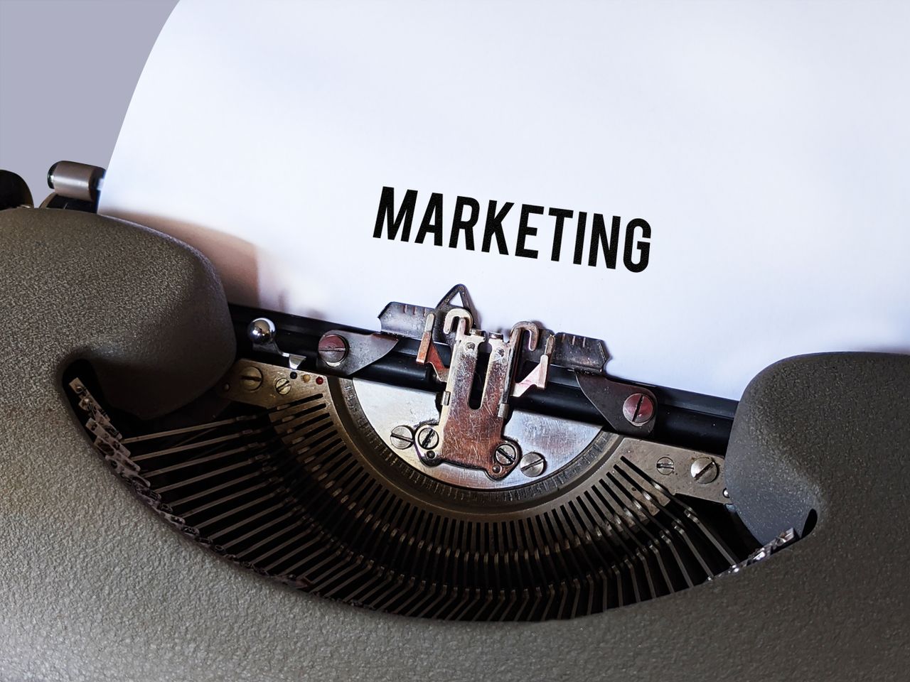 services-bg Close-up of a vintage typewriter with the word Marketing on paper, conveying a retro business theme.