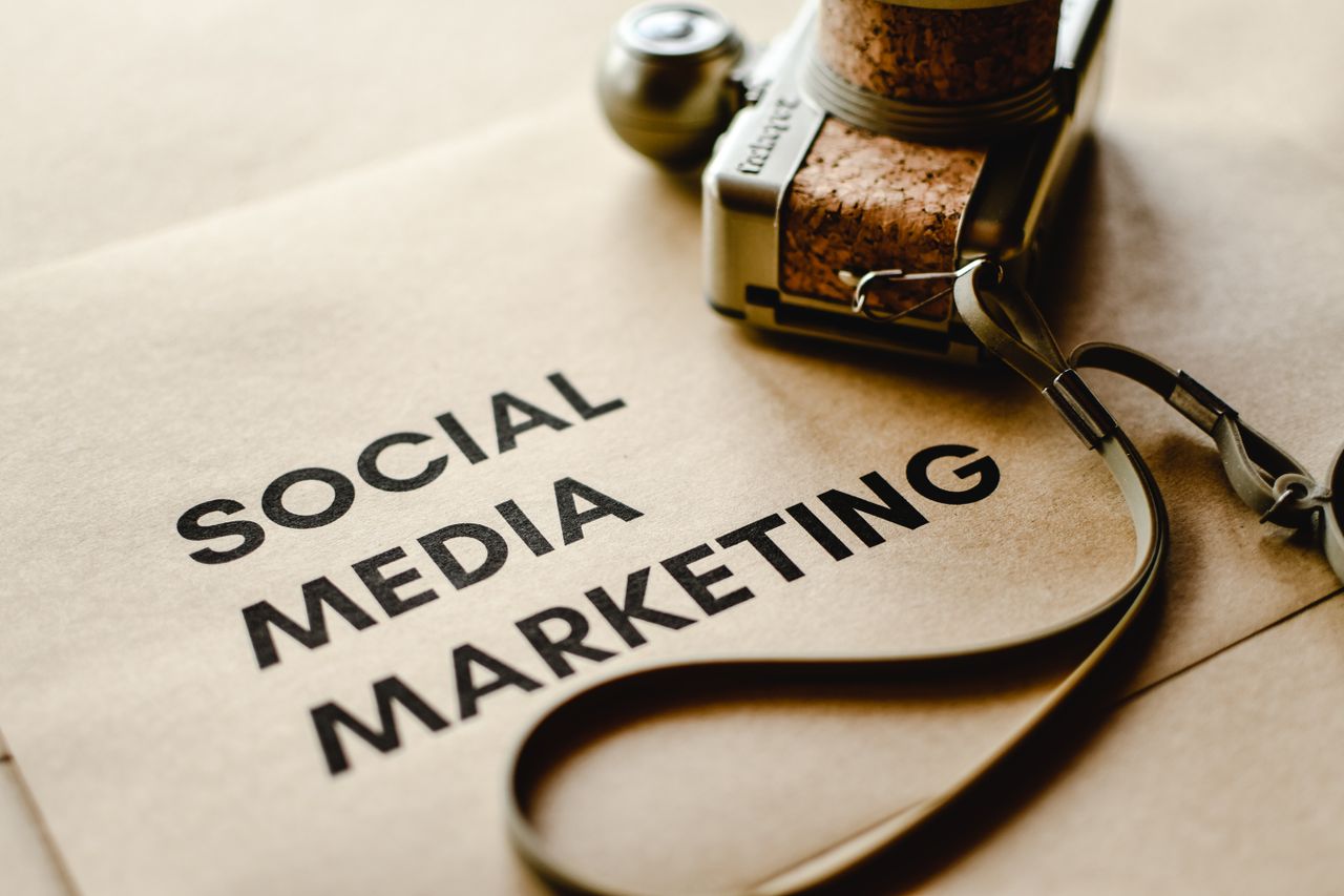 services-06 Close-up of a camera placed on brown paper with Social Media Marketing text, emphasizing digital marketing themes.